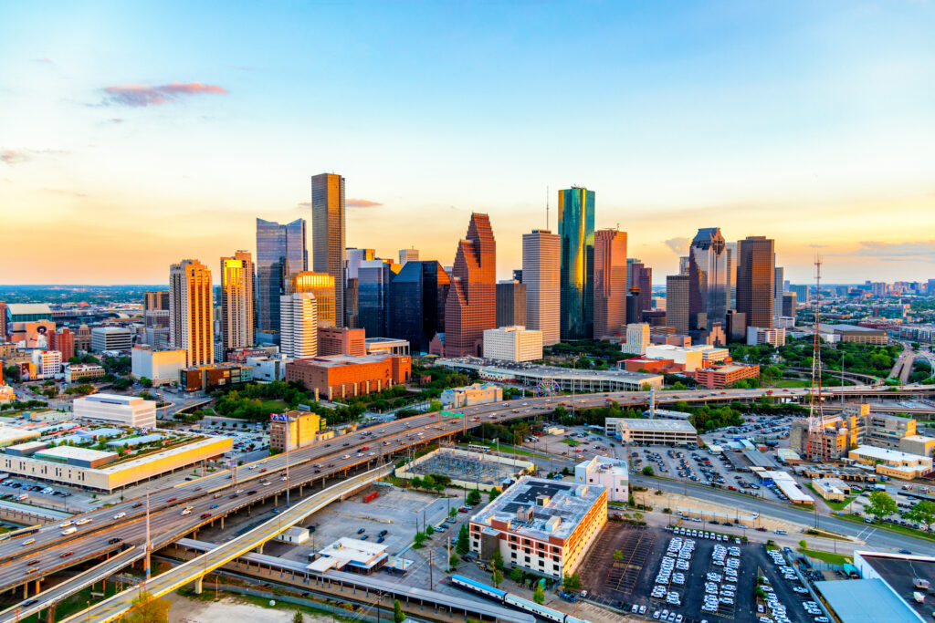 The sun illuminating the face of the buildings of downtown Houston, Texas at sunset on an early spring evening shot from an altitude of about 600 feet during a helicopter photo flight.