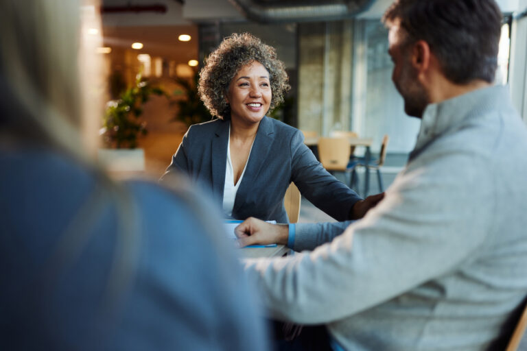 Happy businesswoman communicating with her colleagues during a meeting in the office.