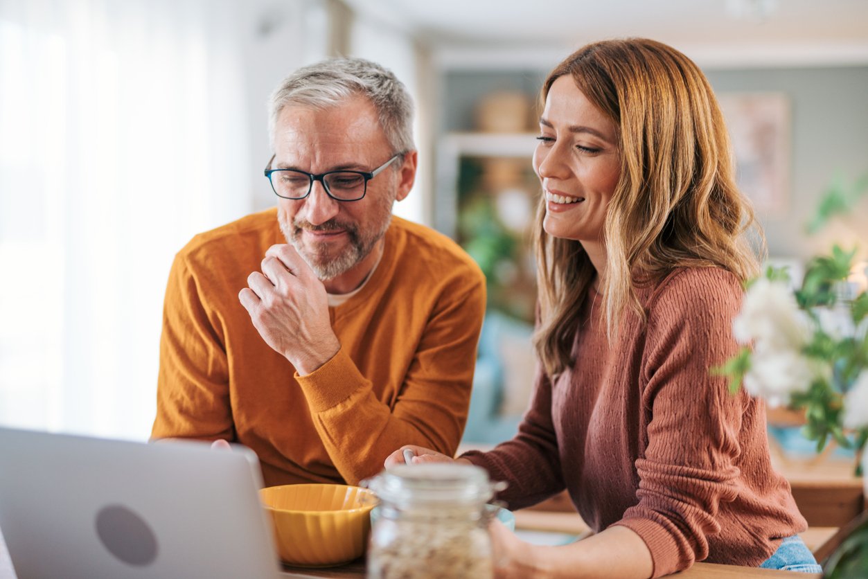 Couples smiling while looking at computer screen